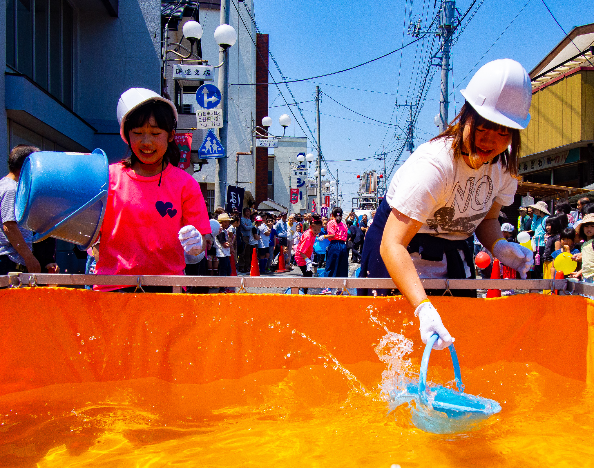 慣れた手つきでバケツリレーをする子どもたち